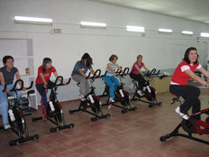 El grupo de aerobic con las bicicletas de spinning